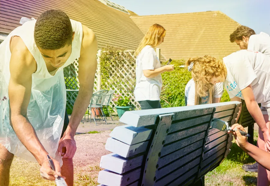 young people painting a bench and helping in the community